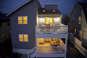 A two-story house with a balcony and a dining area. - Spacious Beach Home – Walk to Beach, Bay & Town (Brigantine)