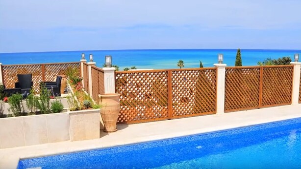 A pool with a view of the ocean, a wooden fence, and outdoor furniture. - Acropolis Sea View Villa - Panoramic Views & Stunning location (Poli Crysochous)