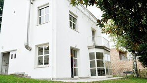 Un edificio blanco con varias ventanas, un balcón y una puerta.