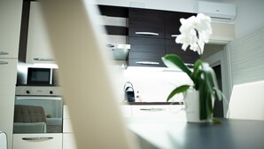 Une cuisine moderne équipée d’un four à micro-ondes, d’un four et d’une machine à café posée sur le plan de travail.