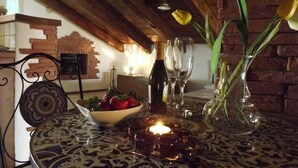 A dining table with a candle, wine glasses, and a vase with flowers. - In the heart of Conversano with a splendid view of the Duomo - Il Nido delle Rondini (Conversano)