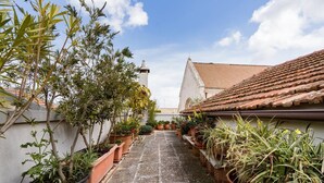 A narrow courtyard with potted plants and a building with a tiled roof. - In the heart of Conversano with a splendid view of the Duomo - Il Nido delle Rondini (Conversano)