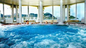 An indoor swimming pool with multiple columns and a view of a mountainous landscape. - BartoloBeachApartment. 100m from La KONTXA Beach (Donostia)