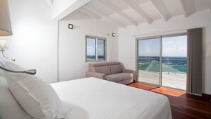 A bedroom with a bed, a chair, a window, and a view of the ocean. - Les Alizés, magnificent villa with breathtaking view (Oyster pond)