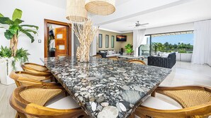 A modern dining area with a marble table, wicker chairs, and a view of the outdoors. - 5 star BEACH VIEW DUPLEX W/ PRIVATE POOL, JACUZZI (Las Terrenas)