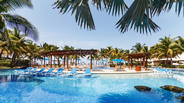 A swimming pool with lounge chairs and palm trees. - BEAUTIFUL CONDO AT THE PACIFIC COAST IN AN EXCLUSIVE LOCATION (El Gariton)