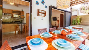 A dining area with a wooden table set for six, surrounded by wooden chairs. - BEAUTIFUL CONDO AT THE PACIFIC COAST IN AN EXCLUSIVE LOCATION (El Gariton)