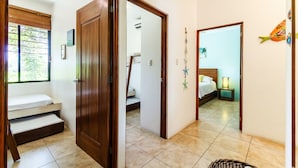 A bedroom with a bed, a nightstand, and a window with blinds. - BEAUTIFUL CONDO AT THE PACIFIC COAST IN AN EXCLUSIVE LOCATION (El Gariton)