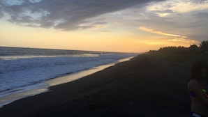 A beach with a clear sky and waves at sunset. - BEAUTIFUL CONDO AT THE PACIFIC COAST IN AN EXCLUSIVE LOCATION (El Gariton)