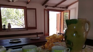 Un coin repas avec une table dressée pour deux personnes, agrémentée d’une carafe, de deux tasses à thé et d’une assiette.