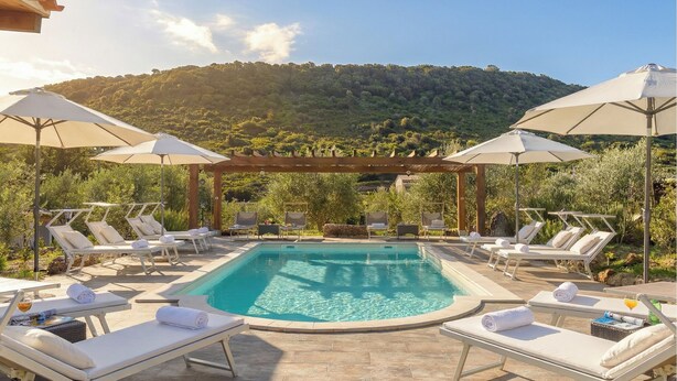 A pool area with sun loungers and umbrellas, surrounded by greenery and hills. - ClickSardegna Alghero Villa Flaminia, with independent swimming pool, SPA & Gym (Alghero)
