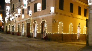 Ein Gebäude mit Rundbogenfenstern und einer Reihe von Lichtern an der Fassade.