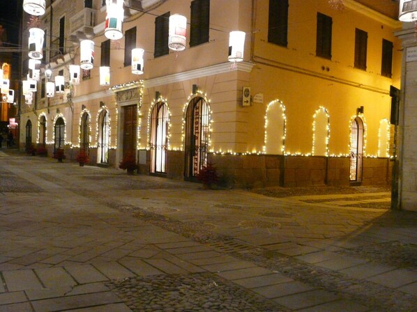 A building with arched windows and a row of lights along the facade.
