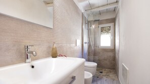 Tina con regadera, secadora de cabello, bidet, toallas 
