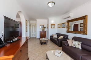 A living room with a flat-screen TV, a sofa, a coffee table, and a cabinet. -  Idyllic Villa near Split, pool, garden, free parking and stunning view, (OWNER) (Solin)
