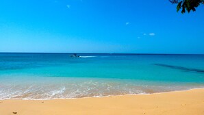 Una playa con agua turquesa cristalina y una orilla arenosa.