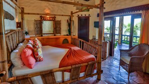 A room with a four-poster bed, wicker furniture, and a stone floor. - Villa Beachcliff,  "The Perfect Island Sanctuary" (Lance Aux Epines)