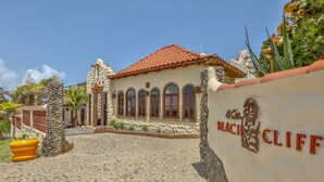 A building with a red-tiled roof, arched windows, and a stone facade. - Villa Beachcliff,  "The Perfect Island Sanctuary" (Lance Aux Epines)