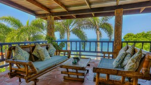 A covered outdoor seating area with bamboo furniture and a view of the sea. - Villa Beachcliff,  "The Perfect Island Sanctuary" (Lance Aux Epines)