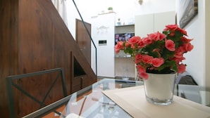 A staircase with wooden steps and a glass table with a vase of pink flowers. - Santa Croce Studio in the historic center (Firenze)