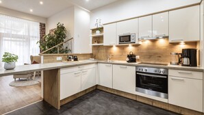 A modern kitchen with white cabinets, a built-in oven, and a microwave. - Apart amber with 135 m² with a large sunny terrace for 6-11 people (Ried im Oberinntal)