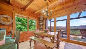 A wooden cabin interior with a dining area, large windows, and a view of the outdoors. - EndlessViewSleeps15.Amazing Viewover  Dollywood&ParrotMtn.Close to Pkwy,private (Sevierville)