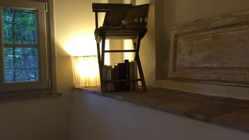 A room with a window, a bookshelf, and a lamp.