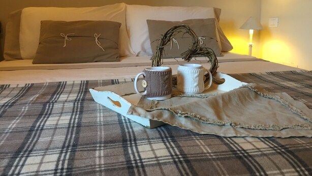 A bed with a plaid blanket, two mugs, and a decorative branch on a tray. - DOUBLE ROOM  (Molina di Quosa-rigoli)