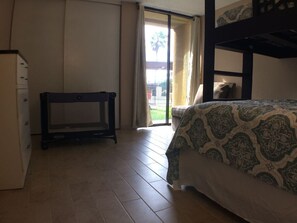 A bedroom with a bed, a desk, and a wardrobe.