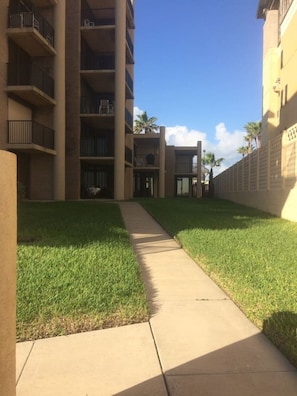 A pathway leading to a building with multiple floors and balconies. - 100 Steps to the beach! Condo 3bedroom 2 bath Sleeps 8 Ocean views (south padre island)