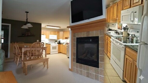 A modern kitchen with wooden cabinets, a built-in microwave, and a fireplace.