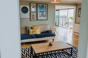 Un salon moderne avec un canapé, une table basse et des œuvres d’art accrochées au mur.
