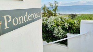 A building with a sign reading "Ponderosa" and a view of the ocean. - 5-Bed Coastal Retreat w/ Studio, Sauna & Sea Views (Newgale)