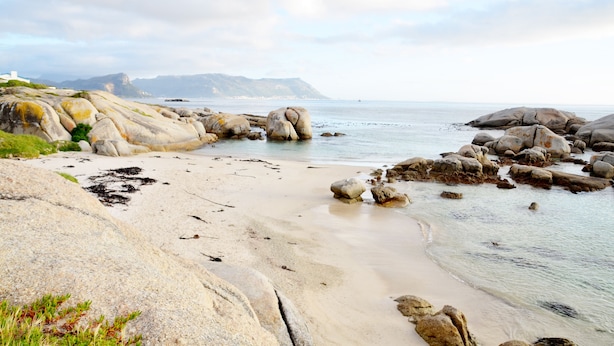 Ein felsiger Strand mit großen Steinen und freiem Blick auf das Meer.