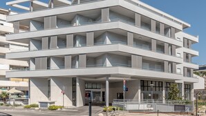 A multi-story building with a modern architectural design, featuring balconies and large windows.