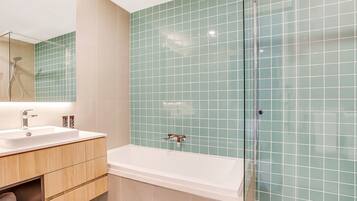 A bathroom with a white sink, mirror, and bathtub.