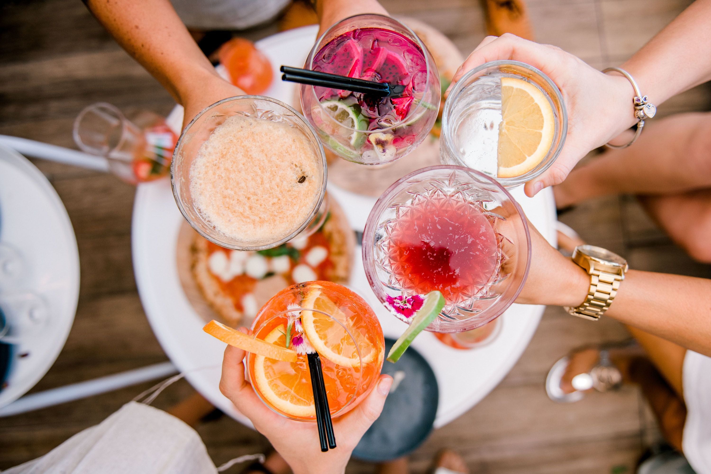 A group of people holding various drinks, likely at a social gathering or party.