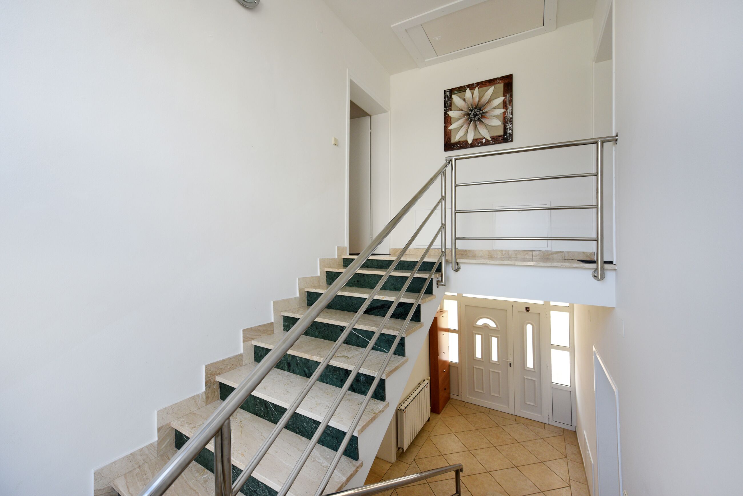Un escalier avec des rampes en métal et une porte en bas.
