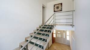 A staircase with metal railings and a door at the bottom. - Apartment Rusula Red (Zadar)