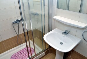 Regadera, secadora de cabello, toallas, papel de baño 
