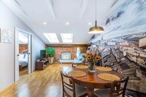 A dining area with a wooden table, woven placemats, and a hanging pendant light.