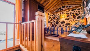A wooden staircase leading to a balcony with a stone wall and a view of the beach. - Adega Velha holiday home, next to the sea and mountains, ideal for couples (Calheta de Nesquim)