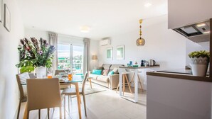 A modern apartment with a dining area, living room, and kitchen. - Elegant and modern in the center of La Cala, just 100 meters from the beach. (La Cala de Mijas)