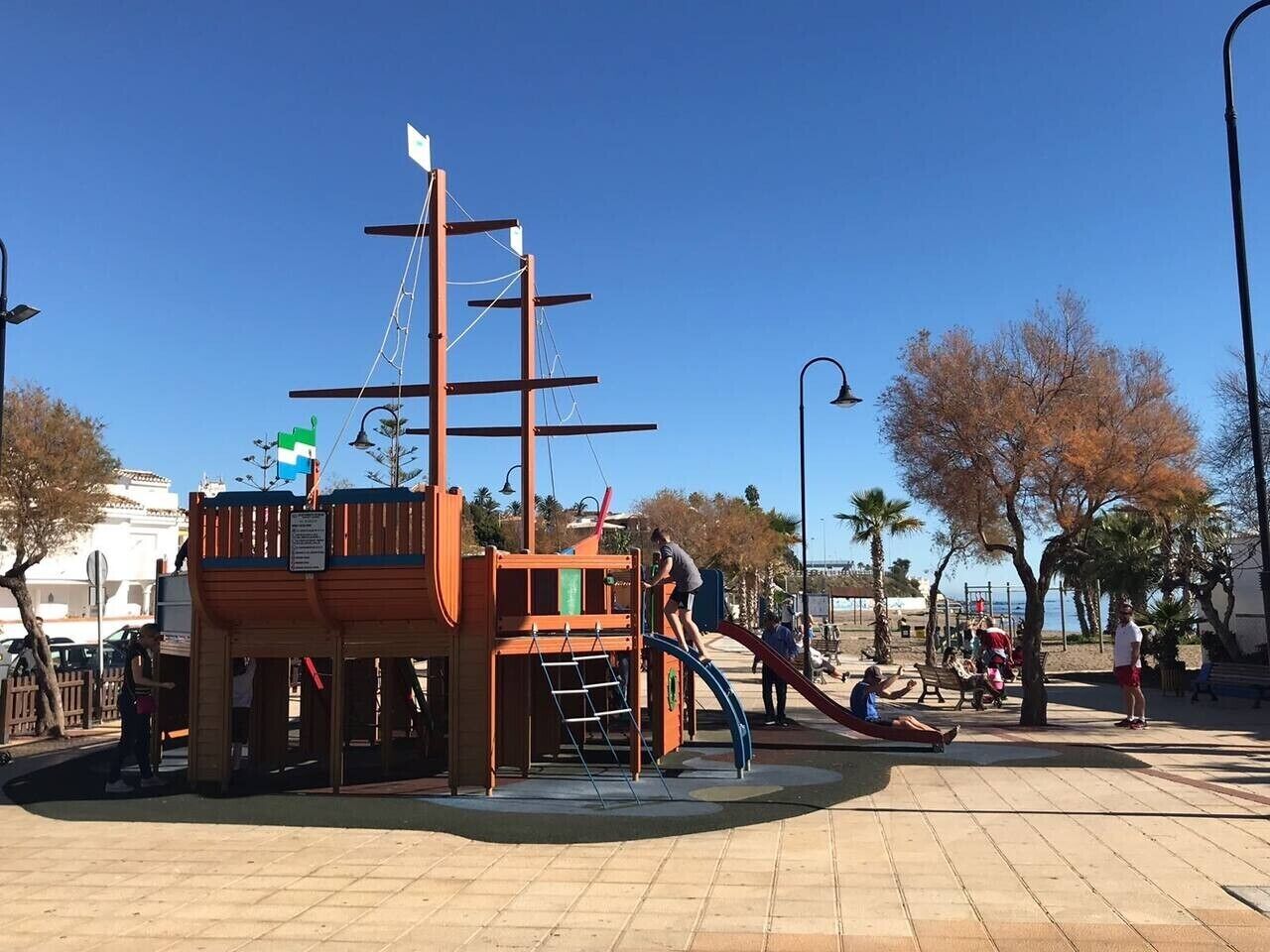 Une aire de jeux avec une structure ludique sur le thème d’un navire, un toboggan et un petit pont.