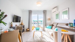 A modern living room with a sofa, coffee table, and dining area. - Elegant and modern in the center of La Cala, just 100 meters from the beach. (La Cala de Mijas)