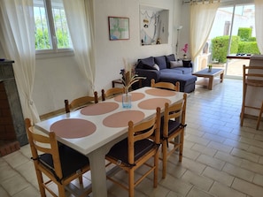 A dining area with a table and chairs, a sofa, and a map on the wall.