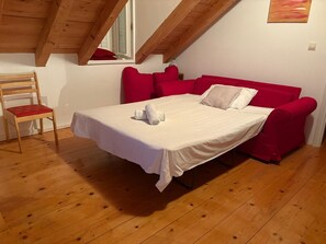 Ein Zimmer mit einem Bett, einem Sessel und einem Fenster.
