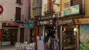 Vista de la calle con un café llamado 'El Mentidero' y una tienda de 'Tabacos'.
