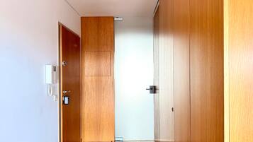 A hallway with wooden doors and a white wall.