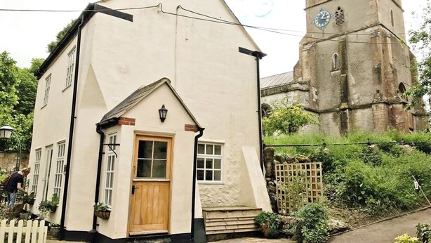 A white building with a wooden door and windows, a small porch, and a brick chimney. - Romantic & Secluded Cottage. Beautiful Walks & Fantastic Pub (Ashbury)